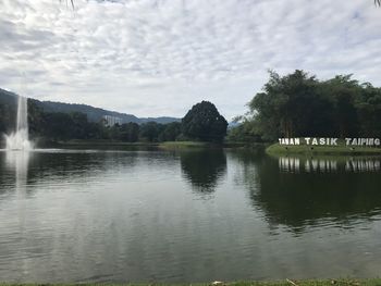 Scenic view of lake by trees against sky