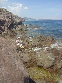 Scenic view of rocks on beach against sky