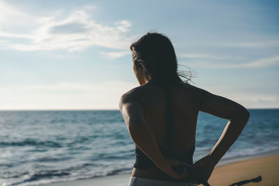 Rear view of woman looking at sea against sky