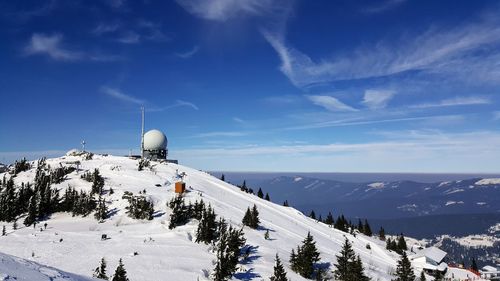 Scenic view of snowcapped mountains against blue sky