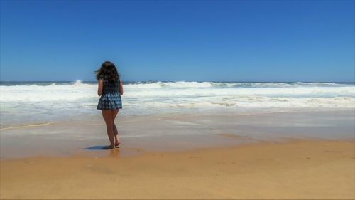 Rear view of man standing on beach