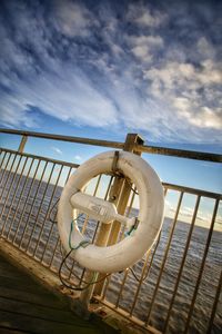 Close-up of railing against sea against sky