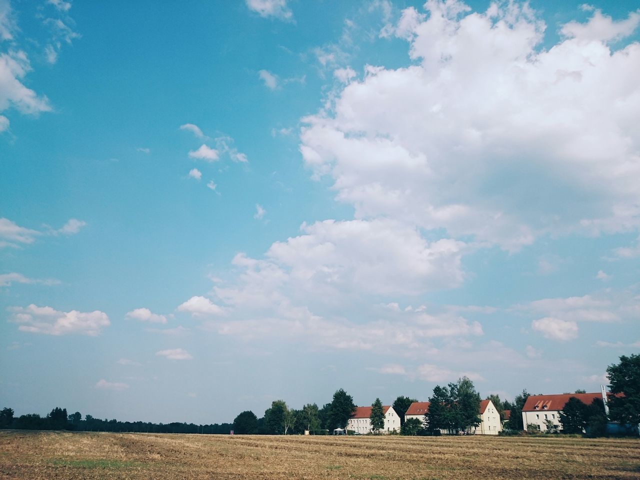 sky, tree, cloud - sky, building exterior, field, landscape, cloud, built structure, architecture, blue, tranquil scene, tranquility, nature, rural scene, house, beauty in nature, scenics, outdoors, day, grass