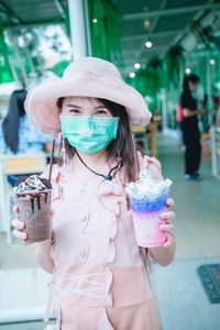 Full length of woman holding hat