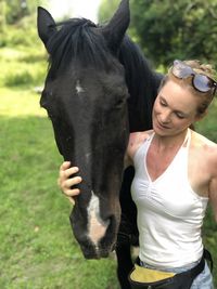 Mid adult woman with horse standing in park