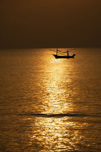 Silhouette boat in sea against sky during sunset