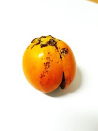 Close-up of orange apple against white background