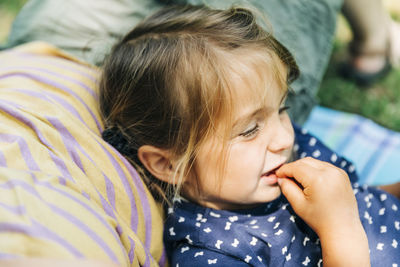 Close-up portrait of cute girl relaxing outdoors