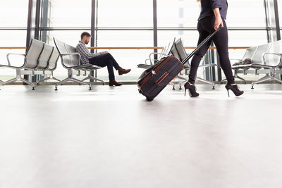 Crop female traveler walking in airport