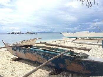 Boats moored on beach against sky