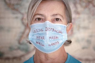 Close-up portrait of woman wearing mask with text