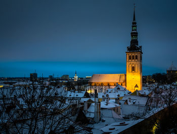 Illuminated buildings against sky during winter