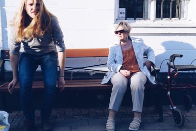 Woman looking at man while sitting on bench