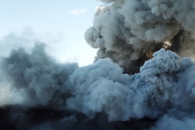 Smoke emitting from volcanic mountain against sky