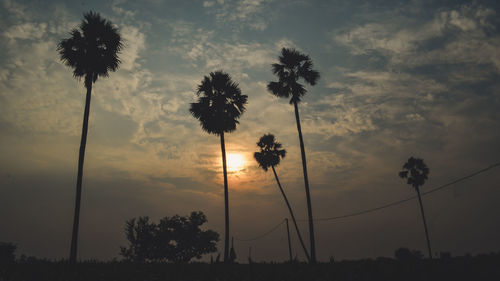 Low angle view of silhouette trees against sky during sunset.