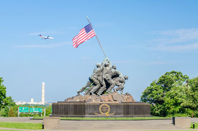 Low angle view of statue of flags against sky