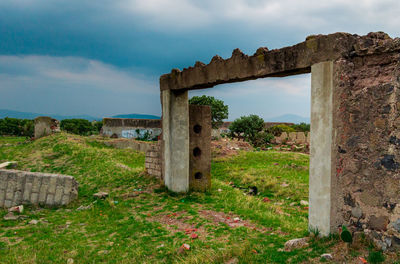 Old ruin on field against sky