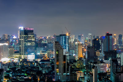 Illuminated buildings in city against sky