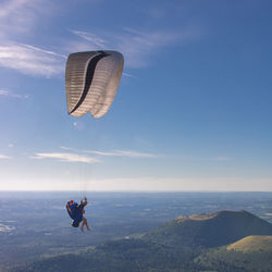 Person paragliding against sky