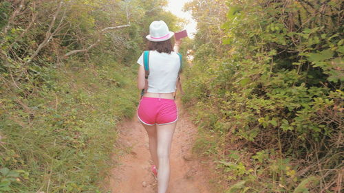 Rear view of young woman walking on grass