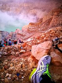 Rear view of man climbing on mountain against sky