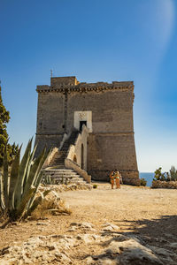 Old ruin building against clear blue sky