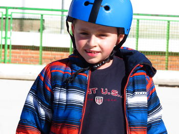 Portrait of boy wearing sports helmet standing at skateboard park