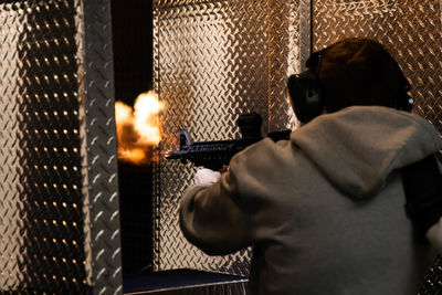 Young man shooting with a gun indoors creating an explosion. usa