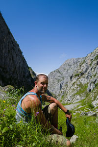 Male hiker in the mountains sitting looking at camera