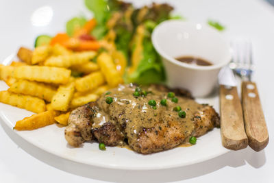 Meat and curry with french fries on plate