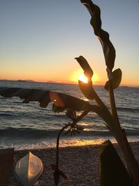 Close-up of beach against sky during sunset