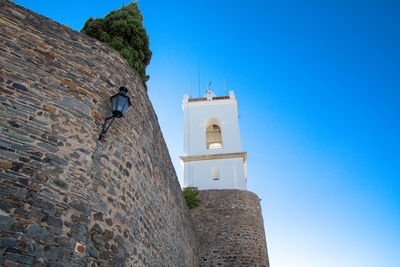 Low angle view of bell tower against blue sky