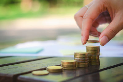 Close-up of hand holding coin stack