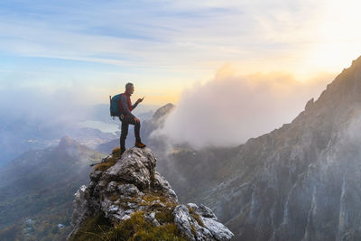 Man standing on rock against mountain range