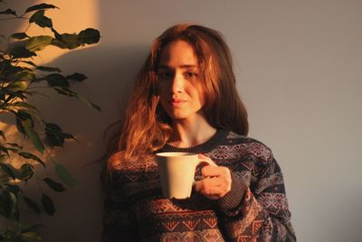 Portrait of young woman drinking coffee