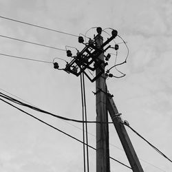 Low angle view of electricity pylon against sky