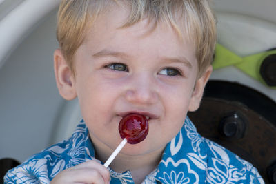 Close-up of cute boy licking lollipop
