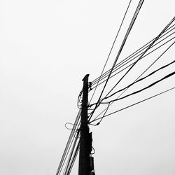 Low angle view of power lines against clear sky