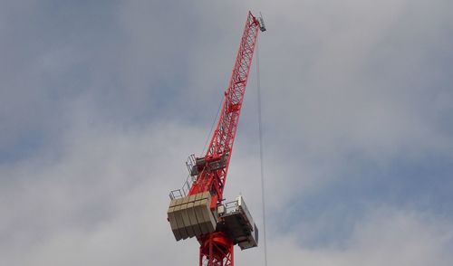 Low angle view of crane against sky