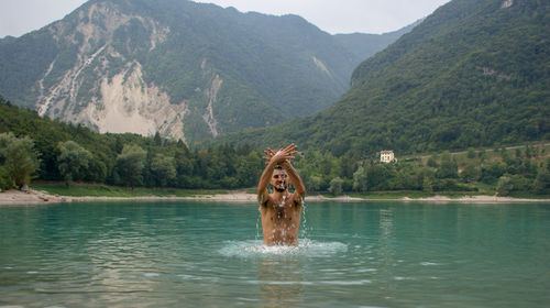 Man in lake against mountains