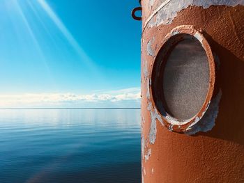 Close-up of metallic pole by sea against blue sky