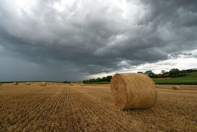 Hay bales on field against sky