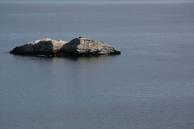 Rock formation in sea against sky