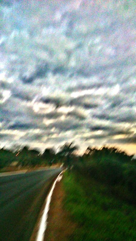 sky, the way forward, road, cloud - sky, landscape, tranquility, tranquil scene, cloudy, field, transportation, nature, beauty in nature, scenics, diminishing perspective, grass, country road, vanishing point, cloud, tree, outdoors