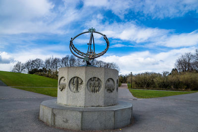 Sundial in vigeland park against cloudy blue sky