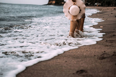 Low section of couple standing on beach