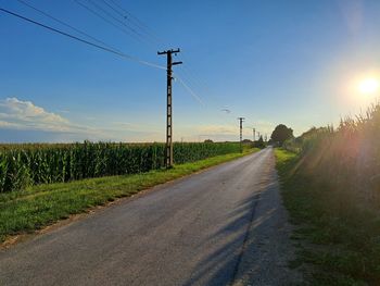 Road amidst field against sky