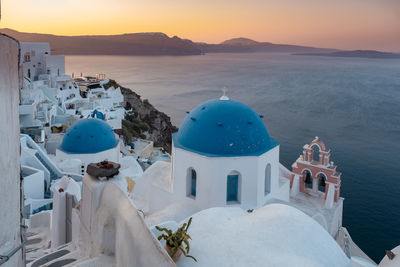 Panoramic view of sea and buildings against sky during sunset