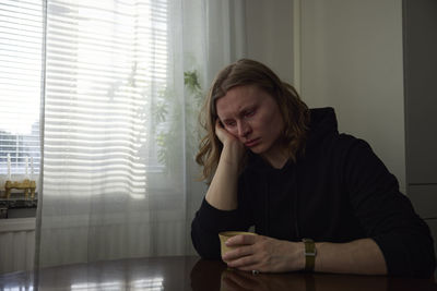 Sad woman sitting at table