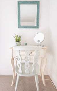 Mirror above dressing table and chair, cottage garden style.